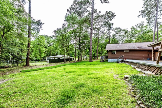 view of yard featuring fence and a deck
