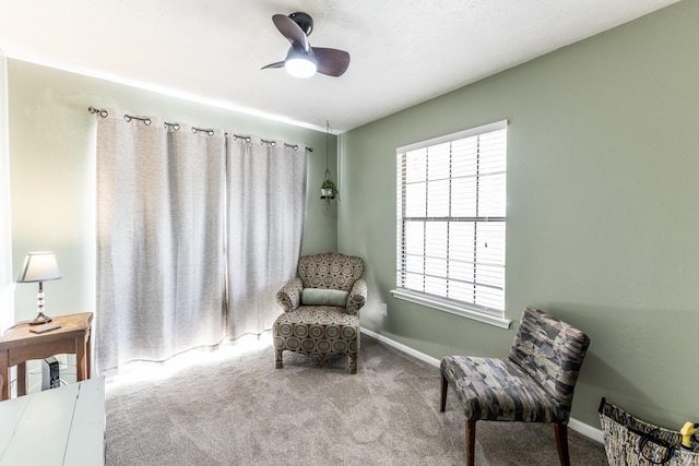 living area with carpet floors, baseboards, and ceiling fan