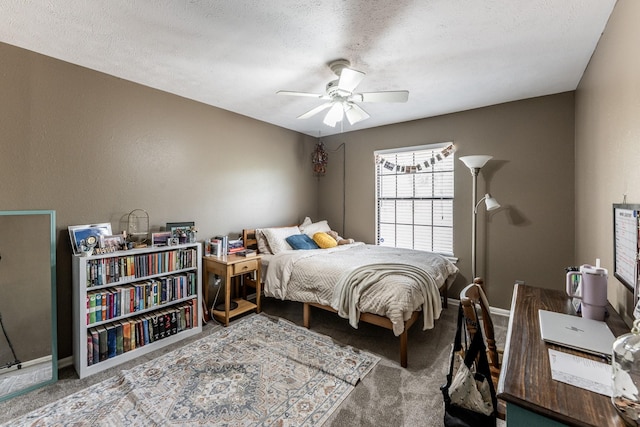 carpeted bedroom featuring a ceiling fan, baseboards, and a textured ceiling