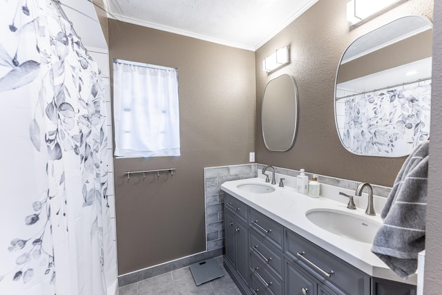 bathroom featuring a sink, tile patterned floors, ornamental molding, and double vanity