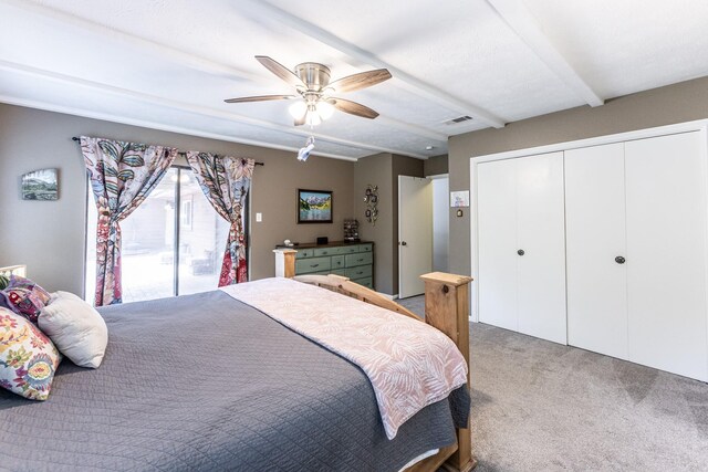 carpeted bedroom with ceiling fan, a closet, beam ceiling, and visible vents