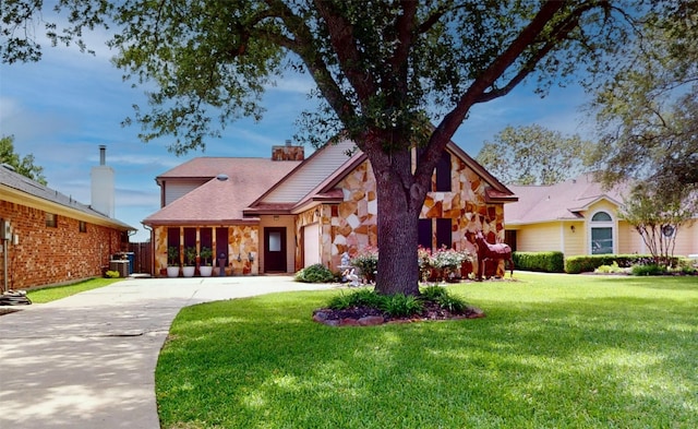 12708 Pelican Blvd, Willis, TX 77318 - view of front facade with stone siding, driveway, a front lawn, a garage, and a chimney