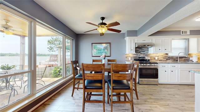 12708 Pelican Blvd, Willis, TX 77318 - dining space featuring a ceiling fan, a water view, and light wood-style flooring