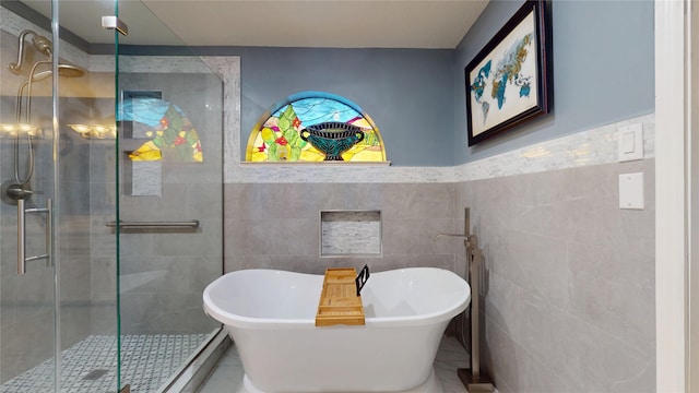 12708 Pelican Blvd, Willis, TX 77318 - bathroom featuring tile walls, a freestanding tub, and a stall shower