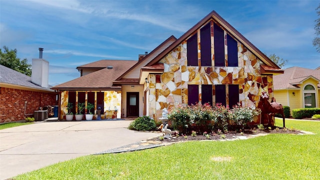 12708 Pelican Blvd, Willis, TX 77318 - view of front of property with stone siding, a front yard, driveway, central AC, and a shingled roof