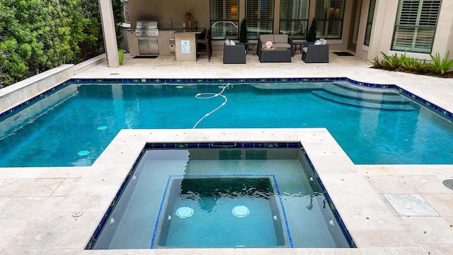 pool with a patio area, an outdoor kitchen, area for grilling, and an in ground hot tub