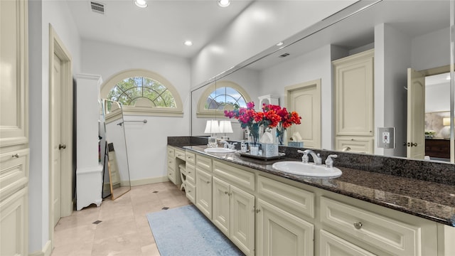bathroom with recessed lighting, double vanity, visible vents, and a sink
