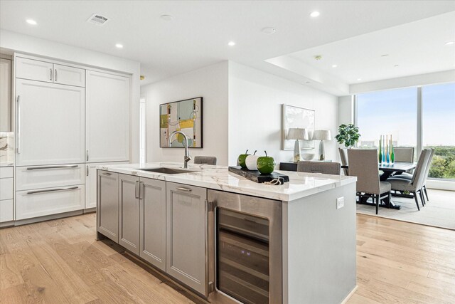 5656 San Felipe St Unit 603, Houston, TX 77056 - kitchen featuring visible vents, light wood-style flooring, a sink, and beverage cooler