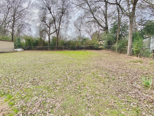 view of yard with fence and an outbuilding