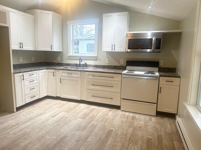 kitchen with baseboard heating, stainless steel microwave, lofted ceiling, and electric stove