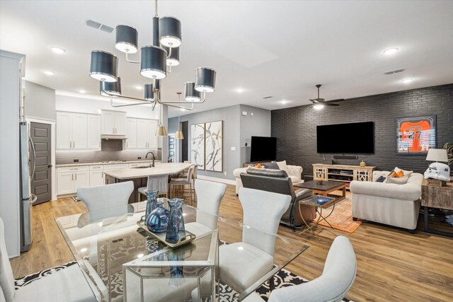 dining room with recessed lighting, light wood-type flooring, visible vents, and ceiling fan with notable chandelier