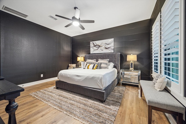 15807 Celebration Ln, Cypress, TX 77433 - bedroom featuring an accent wall, wood finished floors, and ceiling fan