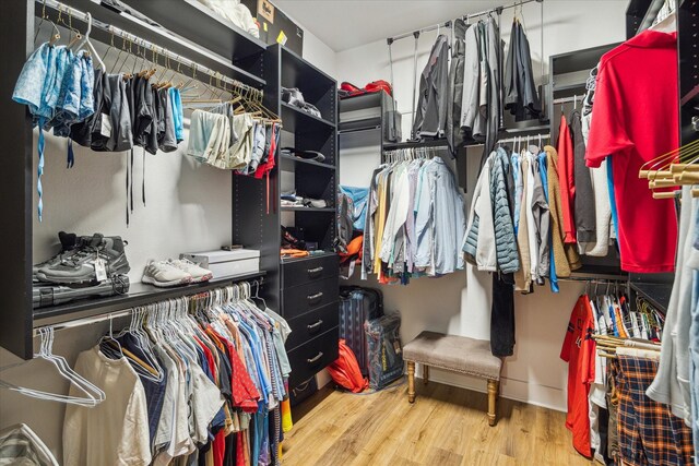 walk in closet with wood finished floors
