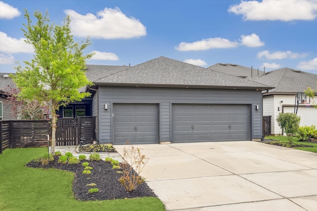 garage featuring fence and concrete driveway