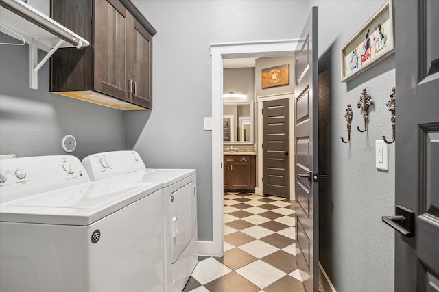 washroom with light floors, cabinet space, washer and clothes dryer, and a sink