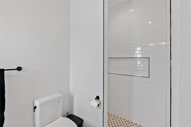 full bath featuring a tile shower and toilet