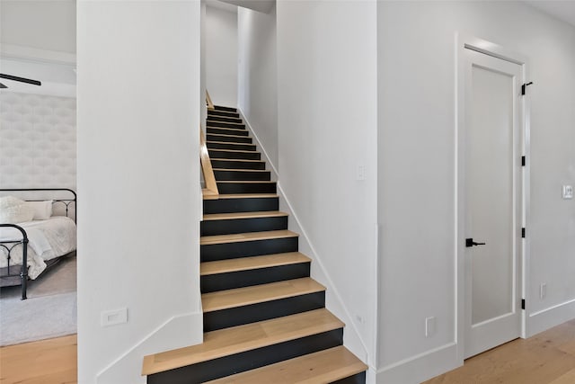 stairway with baseboards and wood finished floors