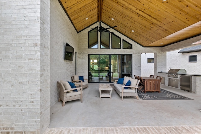 view of patio / terrace featuring an outdoor living space, grilling area, a ceiling fan, and exterior kitchen