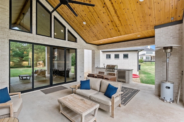 view of patio / terrace featuring grilling area, an outdoor living space, an outdoor kitchen, and a ceiling fan