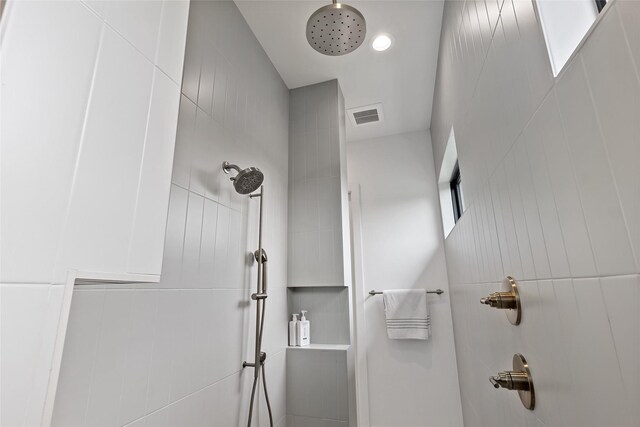 bathroom with visible vents and tiled shower