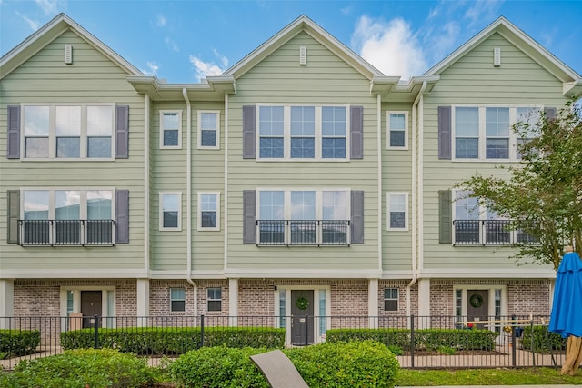 townhome / multi-family property with fence and brick siding