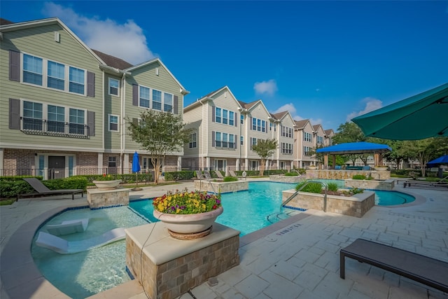 community pool with a residential view and a patio