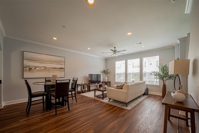 living area with visible vents, ornamental molding, dark wood-style flooring, baseboards, and ceiling fan