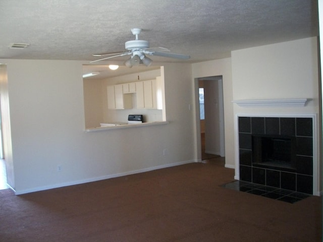 unfurnished living room featuring a tiled fireplace, baseboards, ceiling fan, and visible vents