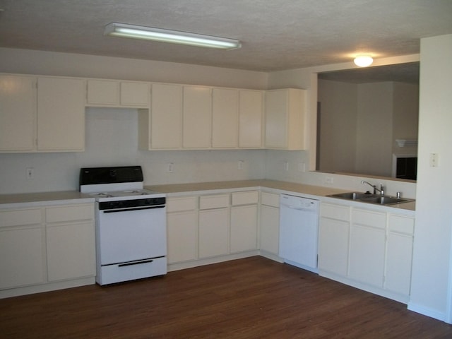 kitchen with white appliances, dark wood-style floors, light countertops, white cabinetry, and a sink