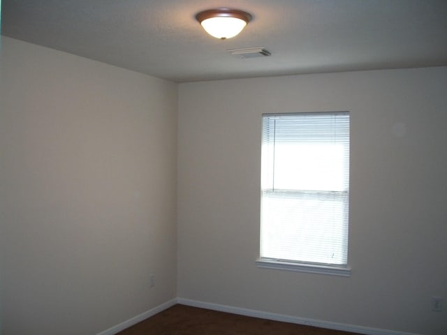 spare room with baseboards and visible vents