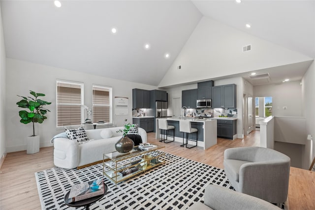 1046 Homer St, Houston, TX 77091 - living area with light wood-type flooring, visible vents, high vaulted ceiling, and recessed lighting