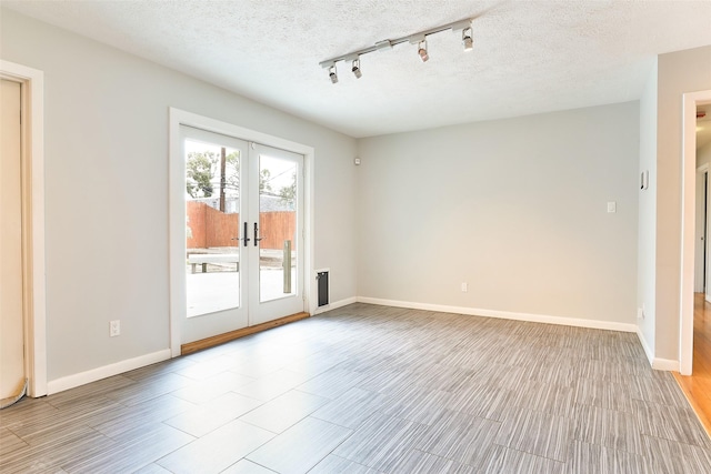 2427 Willowby Dr, Houston, TX 77008 - spare room featuring track lighting, baseboards, french doors, and light wood-type flooring