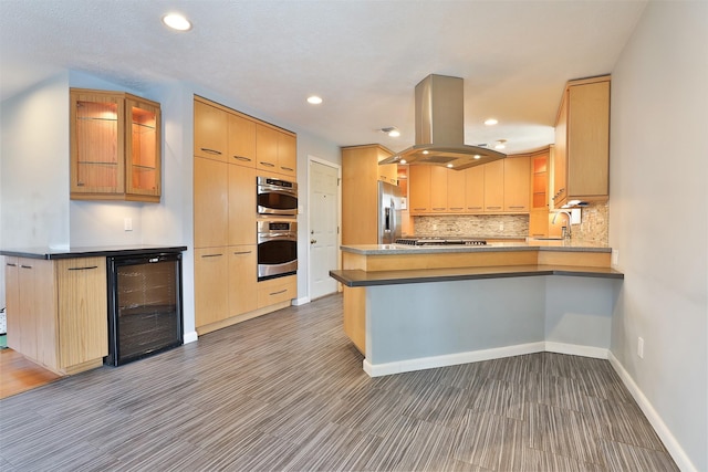 2427 Willowby Dr, Houston, TX 77008 - kitchen with beverage cooler, island exhaust hood, stainless steel appliances, baseboards, and a peninsula
