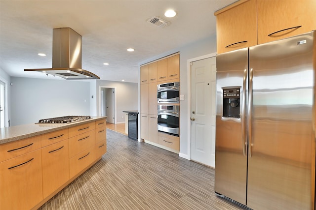 2427 Willowby Dr, Houston, TX 77008 - kitchen featuring light brown cabinetry, island exhaust hood, modern cabinets, stainless steel appliances, and recessed lighting
