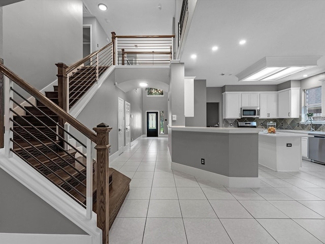 5410 Bur Oak Dr, Pasadena, TX 77505 - kitchen featuring stainless steel appliances, light tile patterned flooring, tasteful backsplash, light countertops, and white cabinets