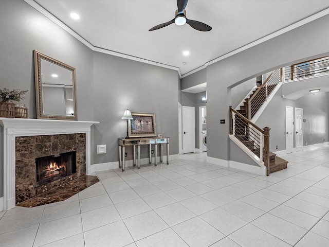 5410 Bur Oak Dr, Pasadena, TX 77505 - tiled living area featuring a ceiling fan, stairway, a premium fireplace, crown molding, and washer / clothes dryer