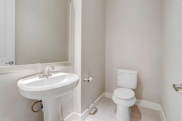 half bathroom with toilet and baseboards