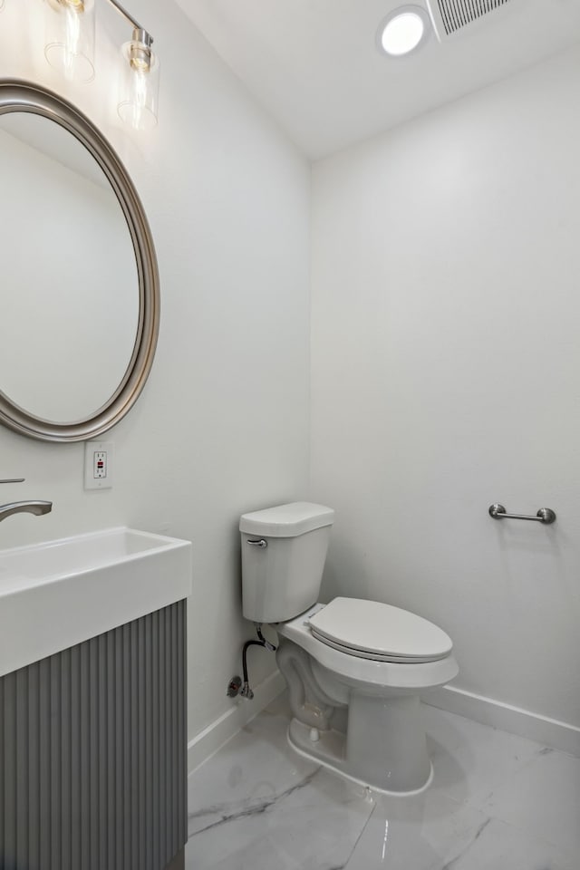 half bathroom with visible vents, marble finish floor, baseboards, and toilet