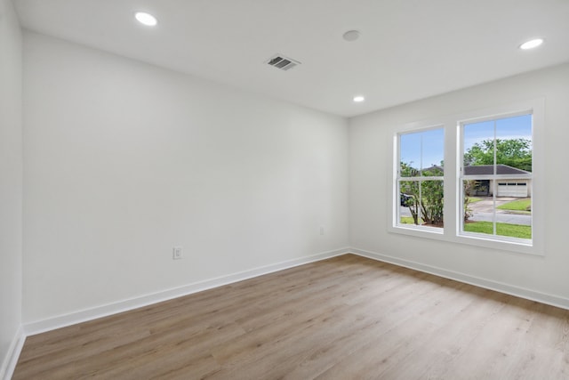 spare room with light wood finished floors, baseboards, visible vents, and recessed lighting