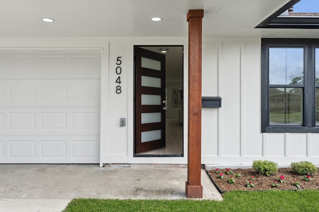 property entrance featuring board and batten siding and a garage