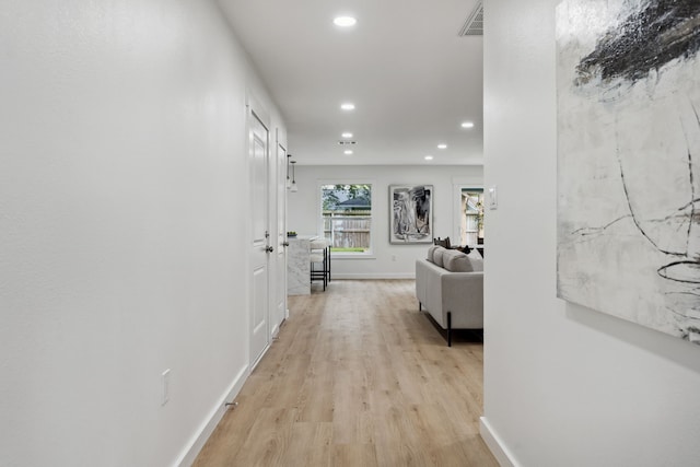 hallway featuring recessed lighting, visible vents, light wood finished floors, and baseboards