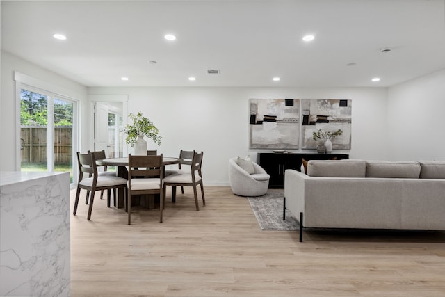 living room with recessed lighting, light wood-style floors, visible vents, and baseboards