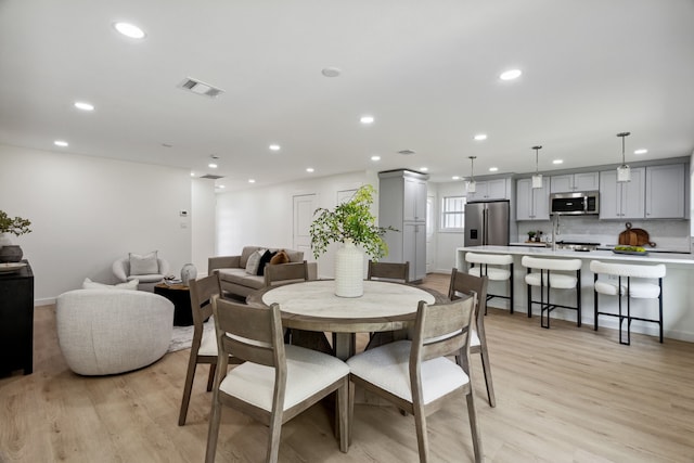 dining space featuring baseboards, recessed lighting, visible vents, and light wood-type flooring