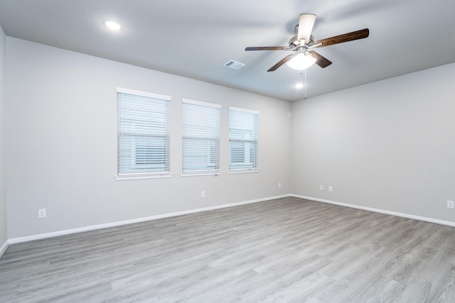 unfurnished room featuring baseboards, ceiling fan, wood finished floors, and visible vents