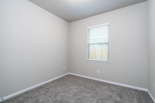 empty room with baseboards and carpet