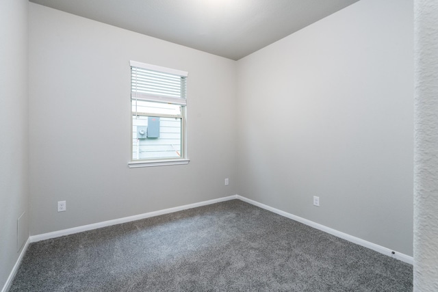 carpeted empty room featuring baseboards
