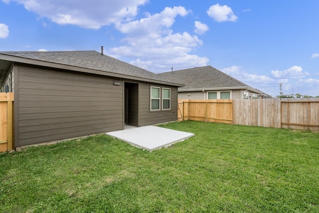 rear view of property featuring a fenced backyard, a lawn, a patio area, and roof with shingles