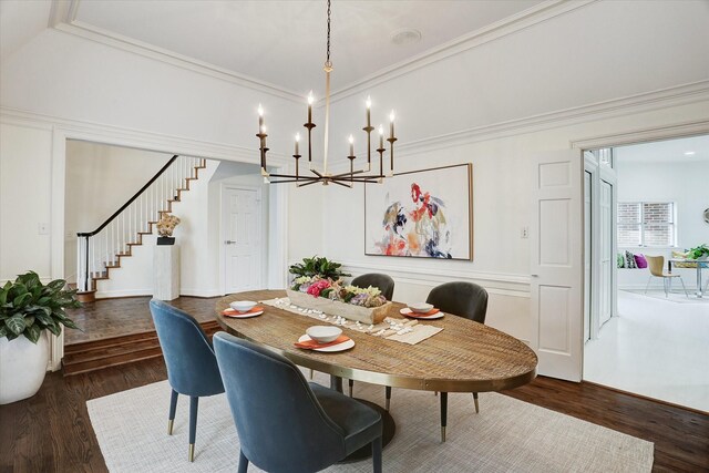 dining space with a notable chandelier, wood finished floors, stairs, and ornamental molding