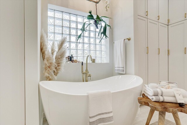 bathroom featuring a freestanding tub and a sink