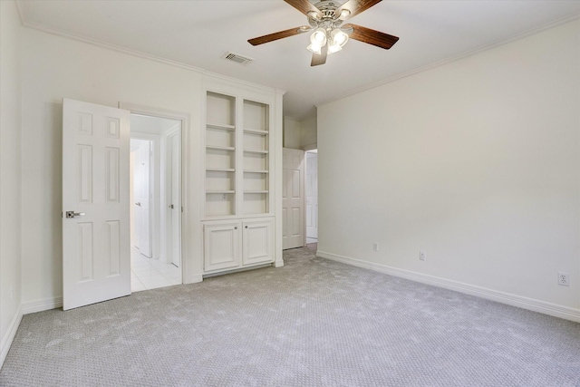 unfurnished bedroom featuring visible vents, a ceiling fan, ornamental molding, baseboards, and light colored carpet